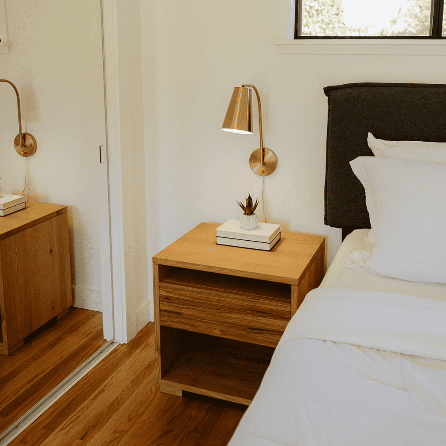 nightstand with books and bedside lamp