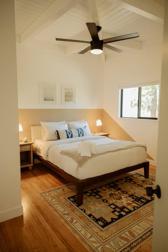 guest room with queen size bed, two nightstands and a rug