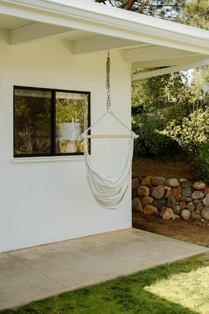 cloth swing with a white house with black windows in the background