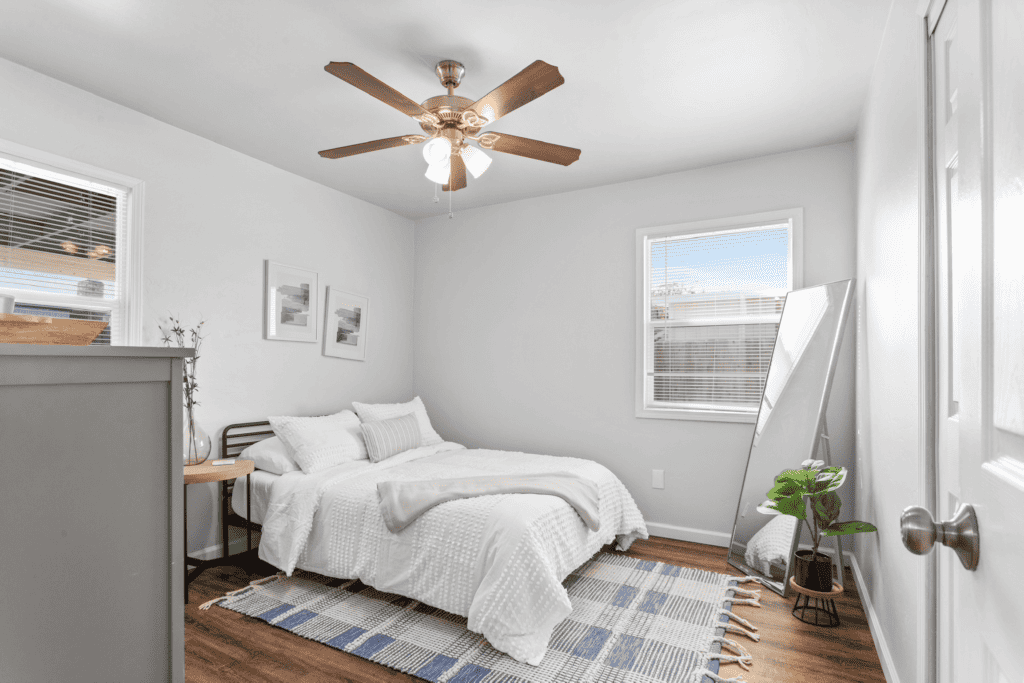 guest room with full size bed, rug, floor length mirror