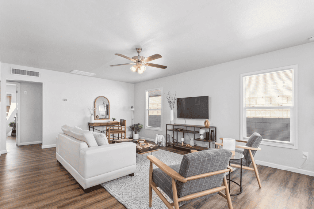 living room with two chairs, couch, TV and entertainment center