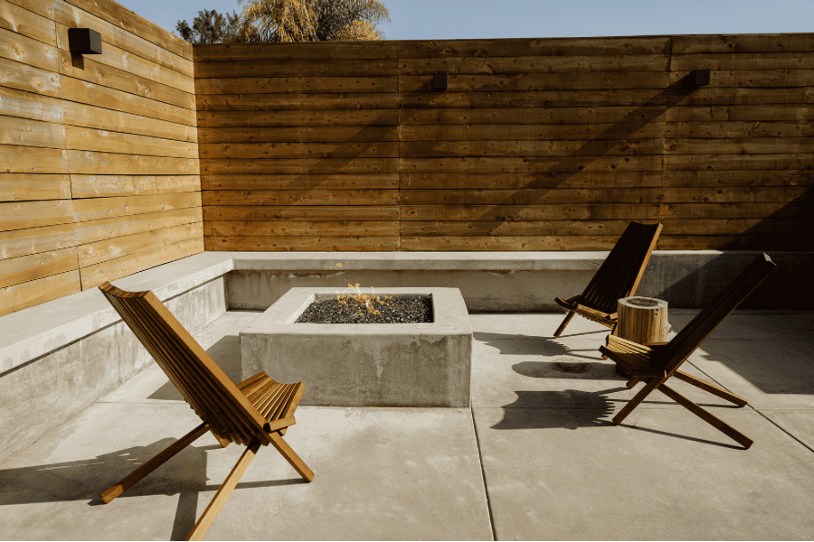 firepit with chairs and a concrete bench